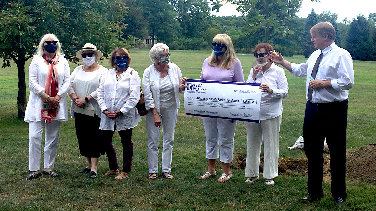 Executive Director Caren Glotfelty (center) receives the first donation to the Suffragist Grove from Women of Wet Weather
