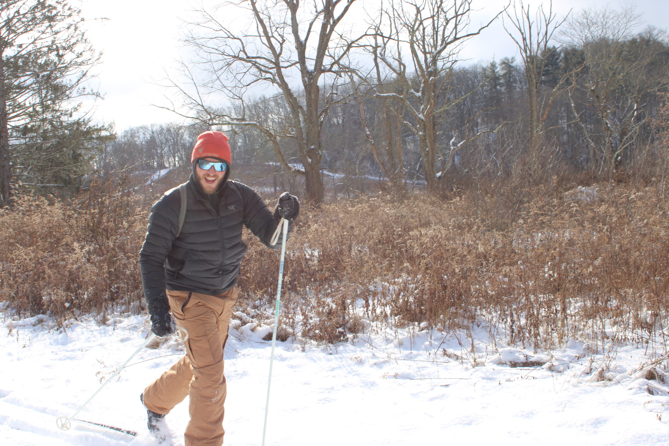 Man cross-country skiing on a snowy meadow trail
