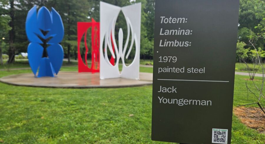 Youngerman Sculpture with sign in front of view. The sign describes the artwork and shows a QR code.
