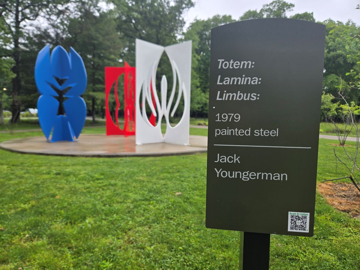 Youngerman Sculpture with sign in front of view. The sign describes the artwork and shows a QR code.